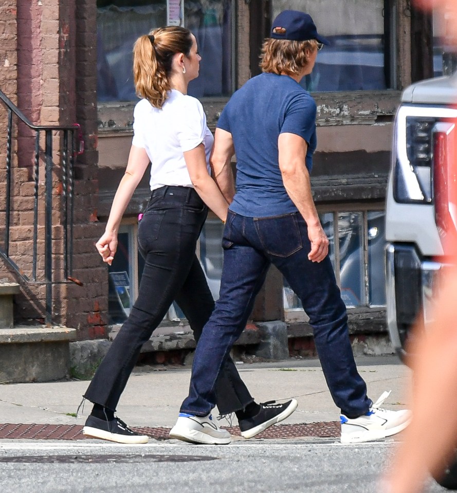 Tom Cruise and Ana de Armas holding hands while walking.