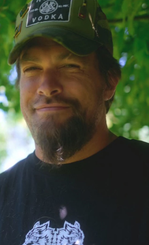 Jason Momoa with a goatee, wearing a camouflage hat.