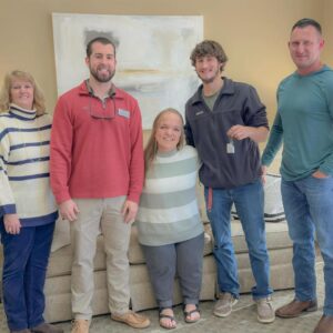 Group photo of five people smiling, holding keys.