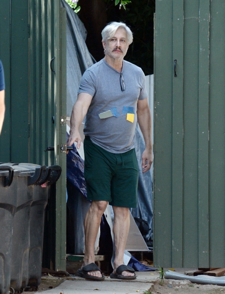 Bronson Pinchot leaving a building.