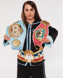 Boxer holding three championship belts.