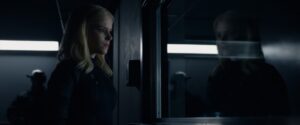 Sue Storm (Kate Mara) looks at her reflection in a military facility window in this scene from the 2015 Fantastic Four.