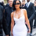Kim Kardashian in a white dress at a fashion show in Paris.