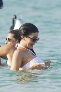 Kylie Jenner in the water wearing a white swimsuit.