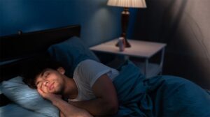 man-sleeping-light-on-nightstand