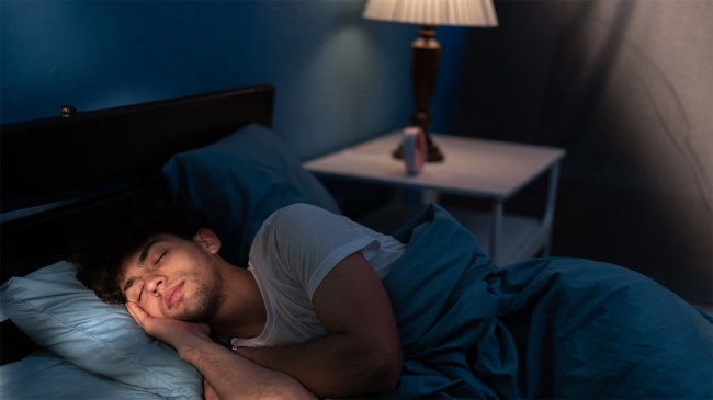 man-sleeping-light-on-nightstand