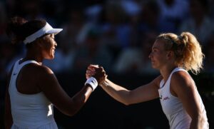 Naomi Osaka shakes hands with Czech Republic's Katerina Siniakova at the end of their women's singles second-round tennis match on the third day of the 2025 Wimbledon Championships