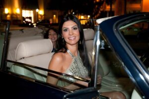 Adriana De Moura in a convertible.