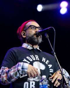 A man singing into a microphone at a concert.