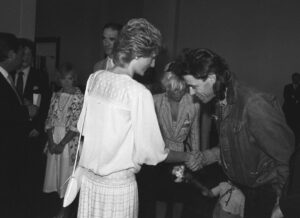 Princess Diana shaking hands with Bob Geldof at a charity concert.