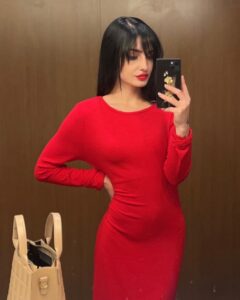 Moriah Plath in a red dress taking a selfie.