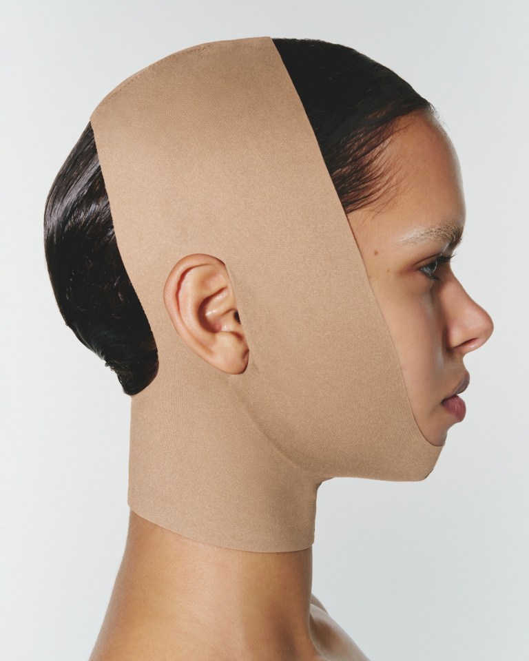 Person wearing a beige face and neck covering.