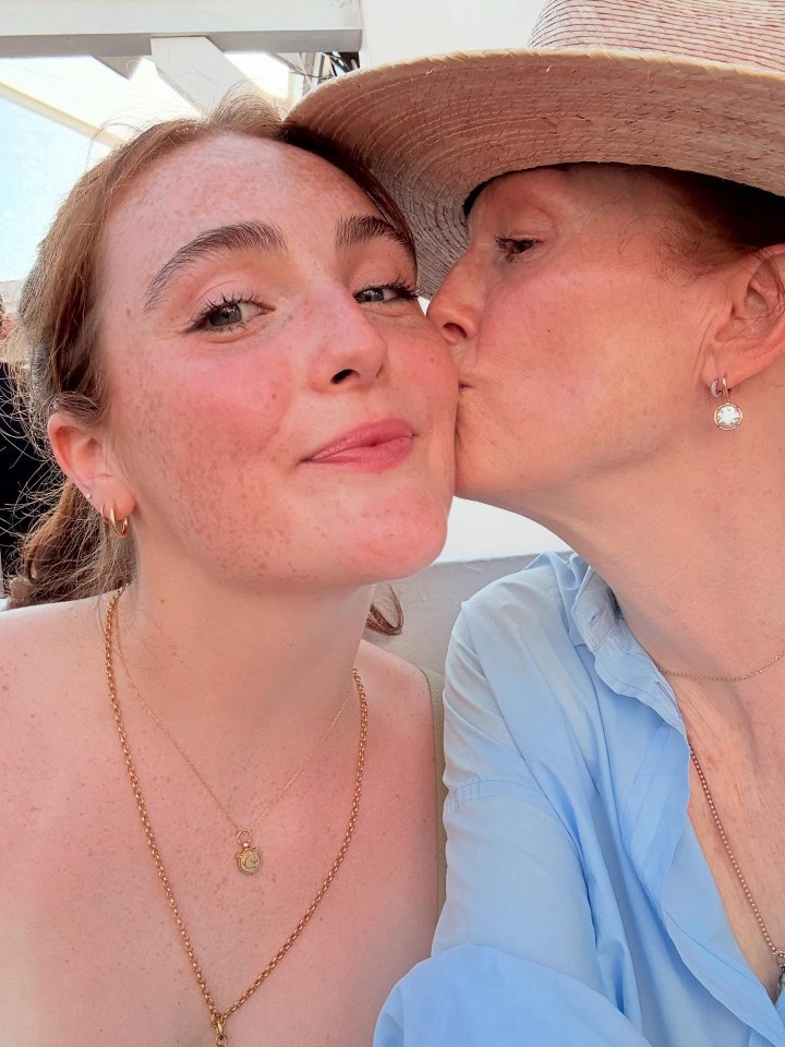 Julianne Moore kissing her daughter on the cheek.
