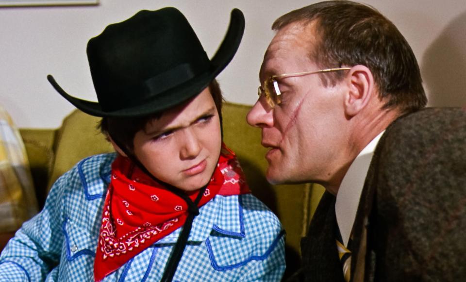 Scene from Willy Wonka & the Chocolate Factory (1971) featuring a boy in a cowboy hat and a man.