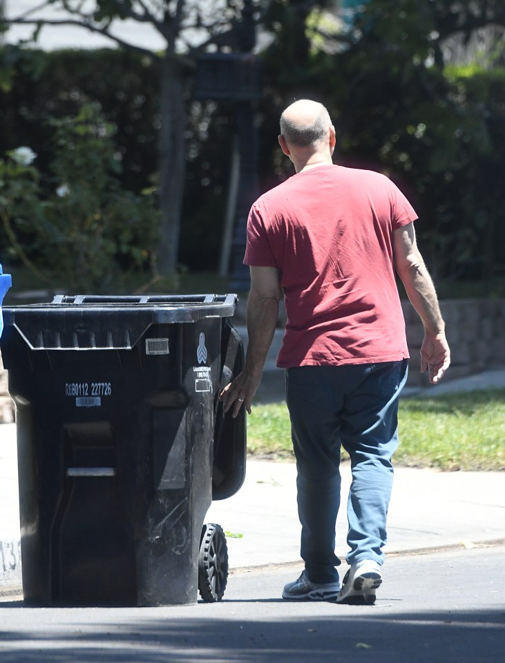 Paris Themmen, former child actor, seen walking down the street while pushing a trash can.