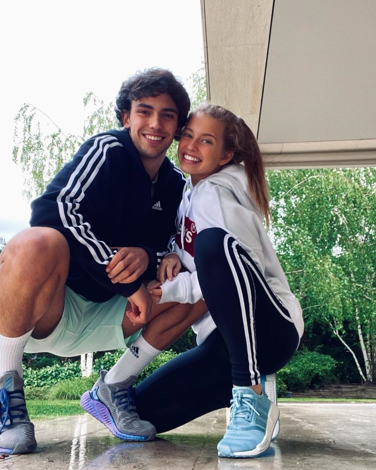 Young couple crouching together outdoors.