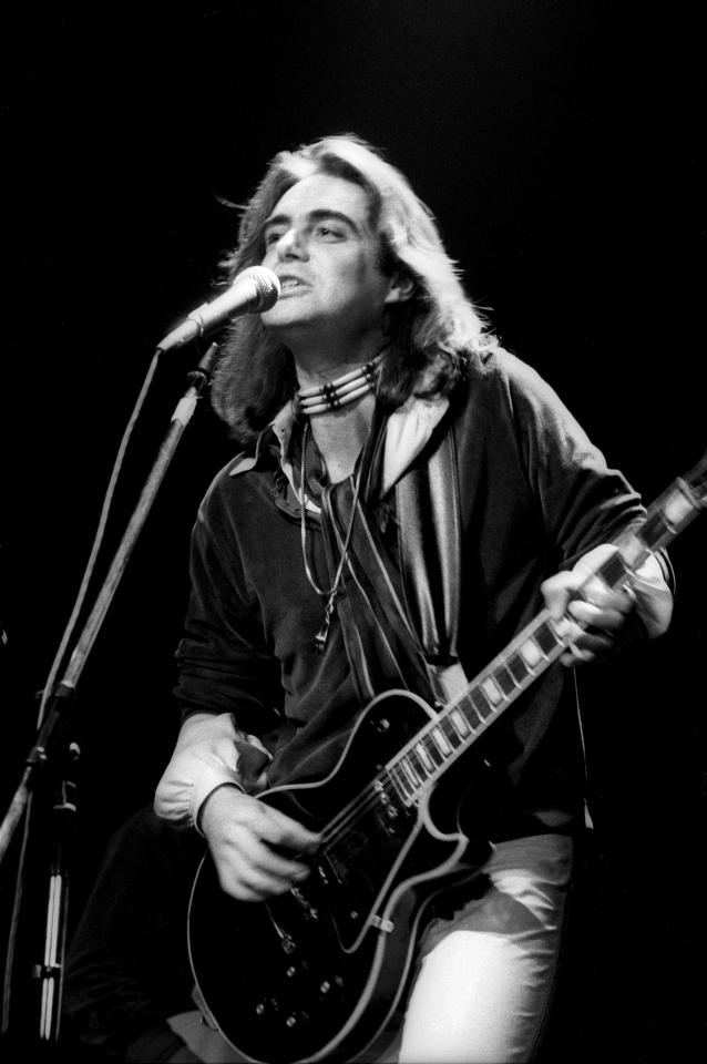 Black and white photo of Terry Reid performing on stage with a guitar.