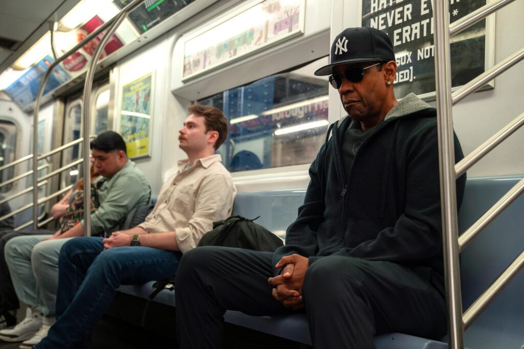 A man in shades and a Yankees cap rides the subway.