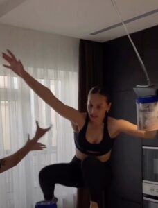 Woman attempting a high-heeled shoes challenge, falling.