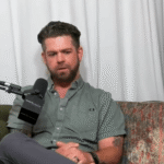 Man sitting on a couch during a podcast interview.