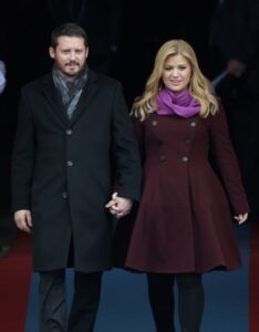 Kelly Clarkson and Brandon Blackstock holding hands.