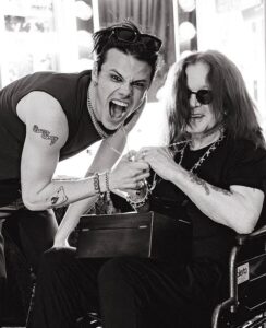 Black and white photo of Ozzy Osbourne receiving a gift from a younger man.