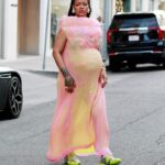 Rihanna walking in Los Angeles wearing a pink dress and Puma sneakers.