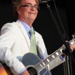 Black and white photo of Terry Reid performing on stage with a guitar.