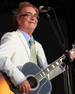 Black and white photo of Terry Reid performing on stage with a guitar.